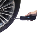Portable digital tire inflator being used on a car wheel