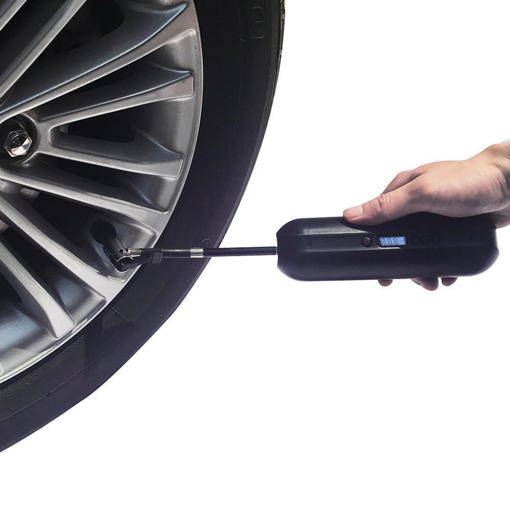 Portable digital tire inflator being used on a car wheel