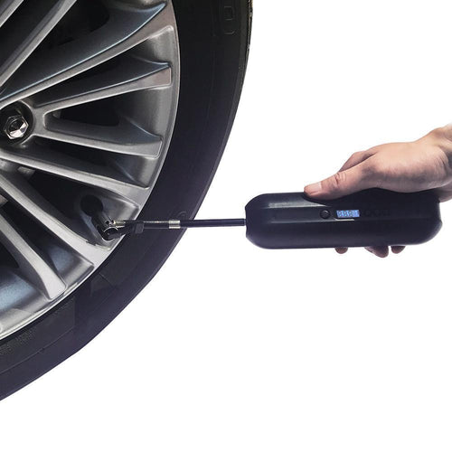 Portable digital tire inflator being used on a car wheel