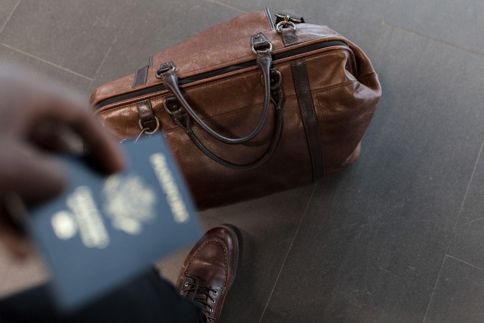 Brown leather weekender duffel bag styled with travel essentials