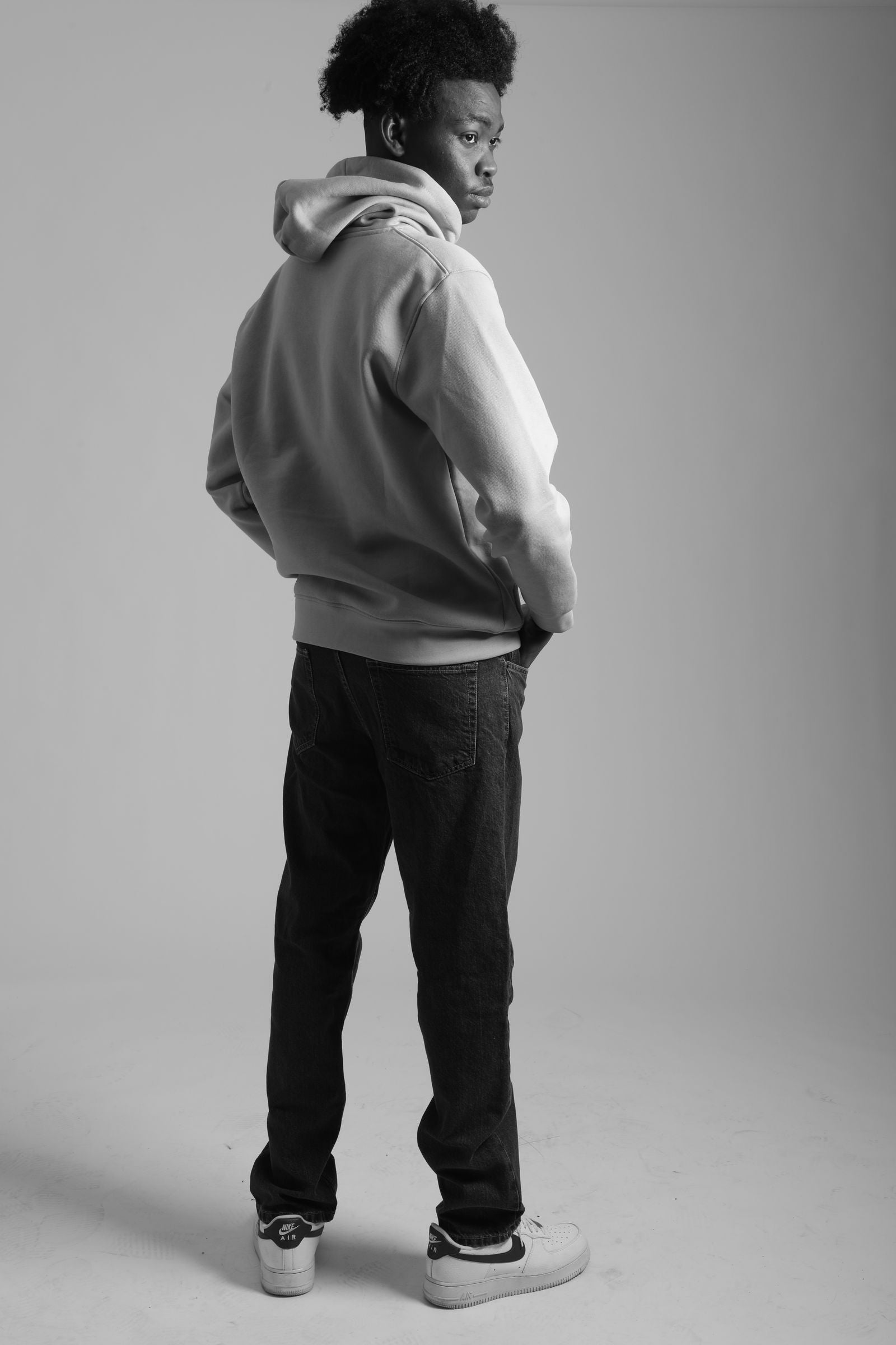 Black and white studio portrait of a man in a premium heavyweight hoodie