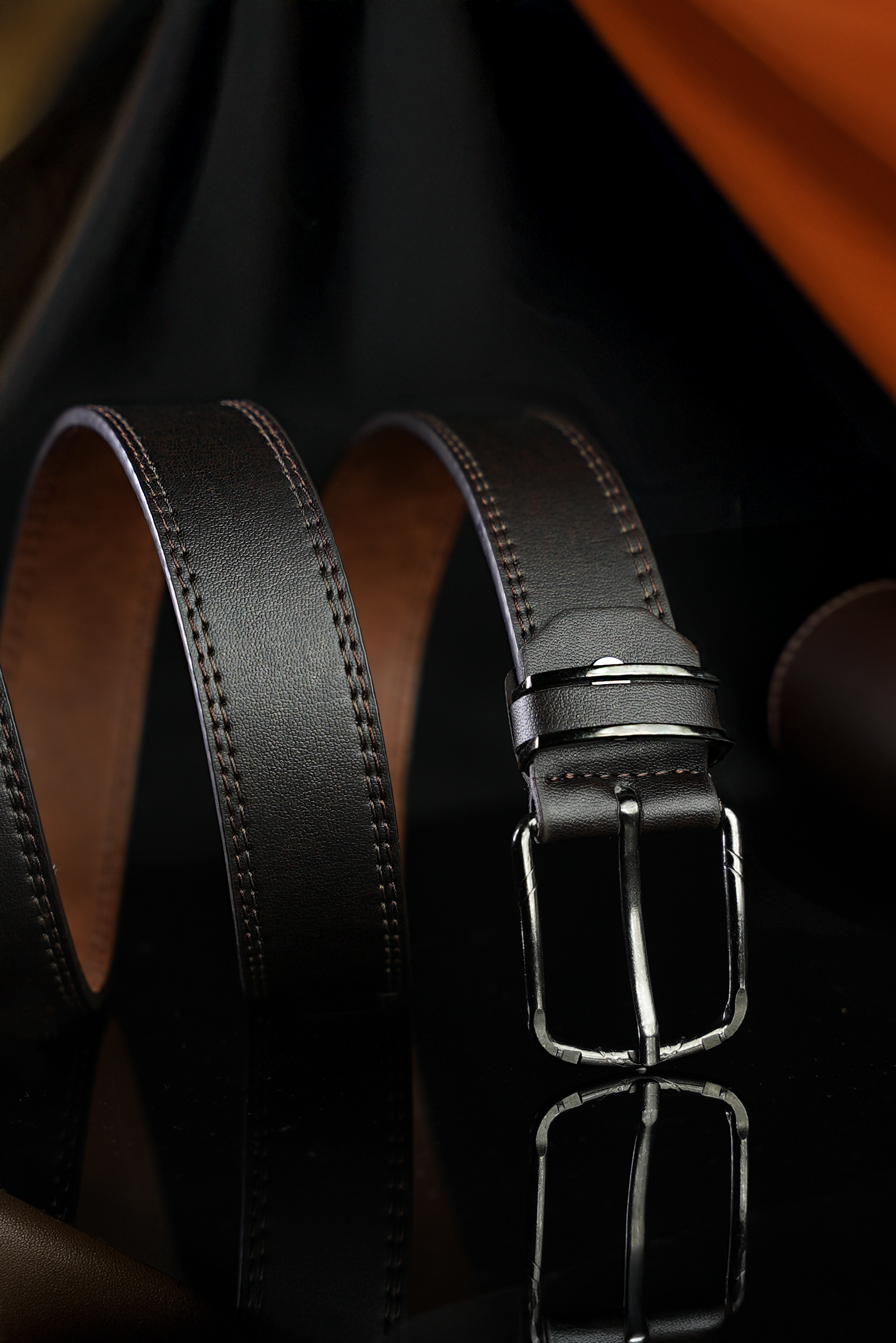 Elegant black leather belt with metallic buckle, clean product photography