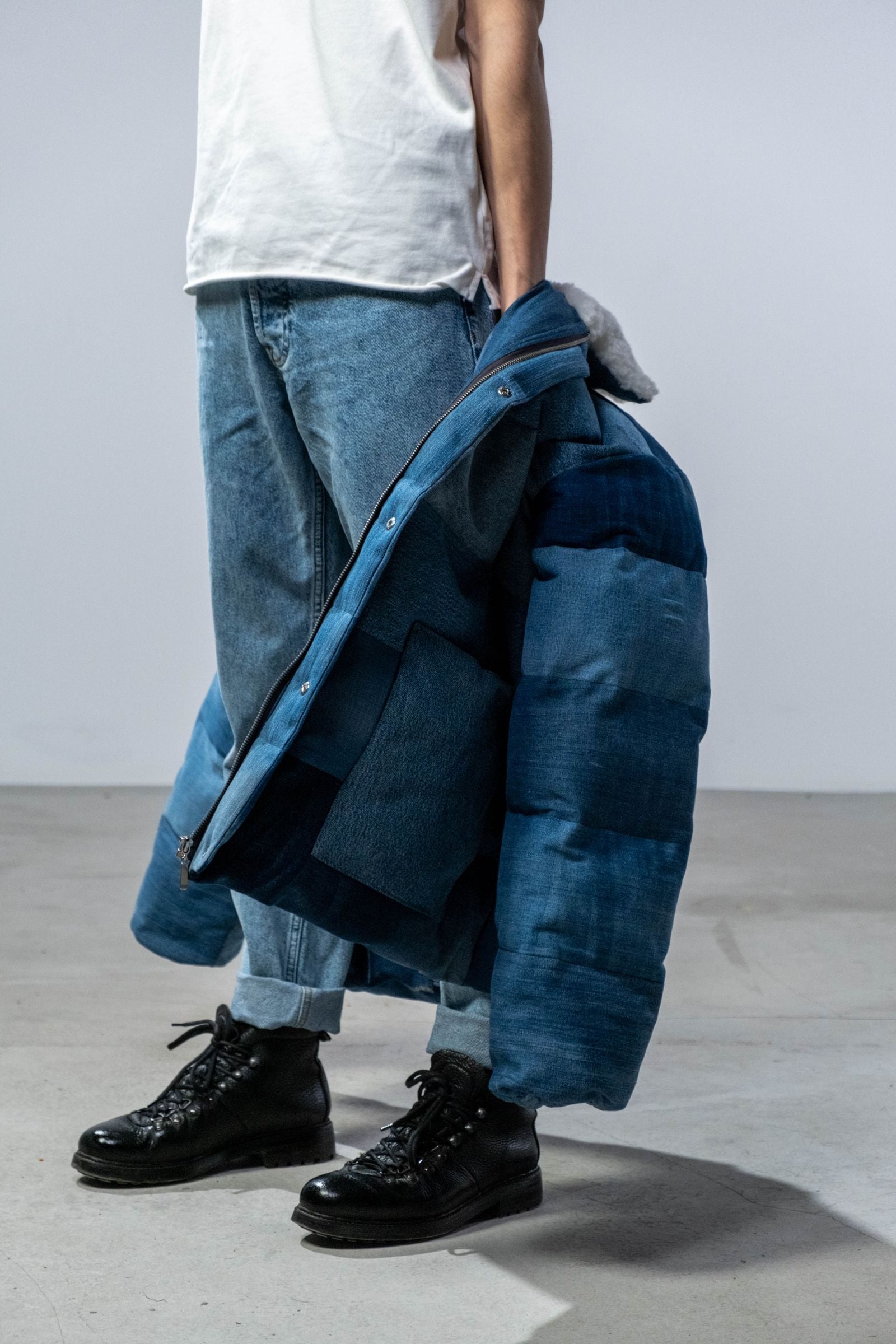 Man wearing raw blue denim jeans in a minimal studio setting