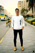 Man wearing a minimal white crew-neck sweater on a city street
